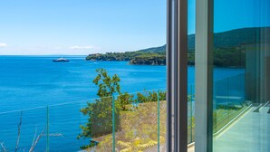 A balcony with a clear view of the sea and a distant island. - Hotel Plaza (Porto Azzurro)