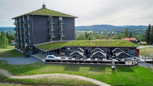 A modern building with a green roof and multiple balconies. - Bergshotellet (Jarvso)