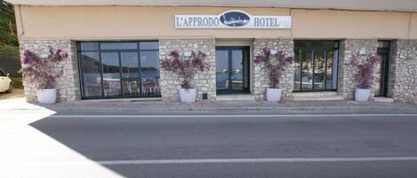 La façade d’un hôtel, sur laquelle on peut lire l’inscription « L’Approdo Hotel ».