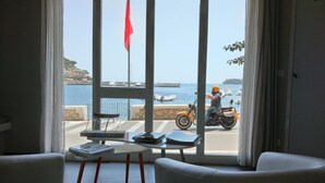 Una habitación con vista al puerto, una mesa con dispositivos electrónicos y una motocicleta afuera.