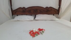 A bed with a wooden headboard and white pillows. - St. Gotthard Motel Bar & Restaurant (Malindi)