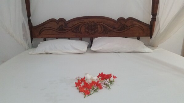 Una cama con cabecera de madera y almohadas blancas.