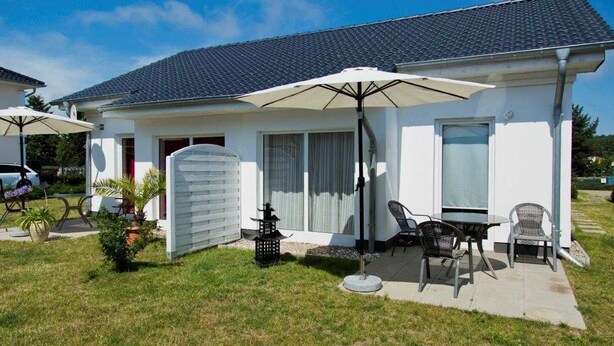 A single-story house with a patio area featuring outdoor furniture and a large umbrella. - Vacation apartment 2 - Ück - Rolletschke Andreas (Ückeritz)