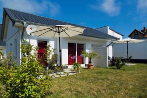 A house with a satellite dish, a covered patio with chairs, and a lawn. - Vacation apartment 2 - Ück - Rolletschke Andreas (Ückeritz)