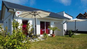 A house with a satellite dish, a covered patio with chairs, and a lawn. - Vacation apartment 2 - Ück - Rolletschke Andreas (Ückeritz)