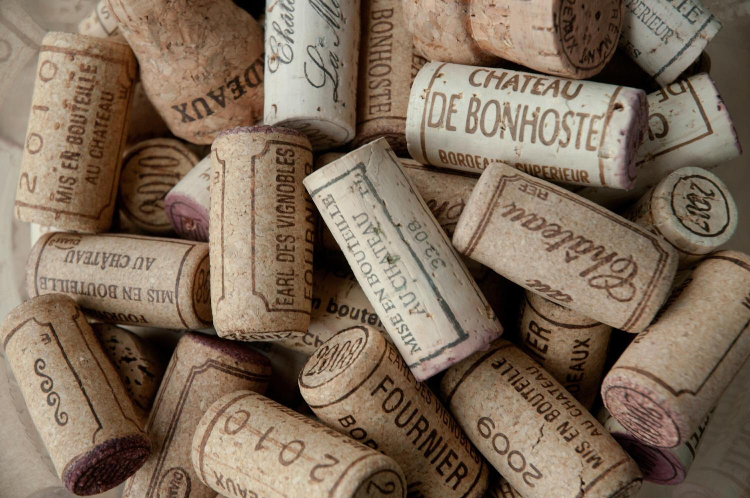 A collection of vintage wine corks with inscriptions.