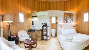 A cozy room with a bed, two chairs, a small table, a TV, and a kitchen area with a sink and cabinets. - Coup 2 Foudres (Saint-Jean-de-Blaignac)
