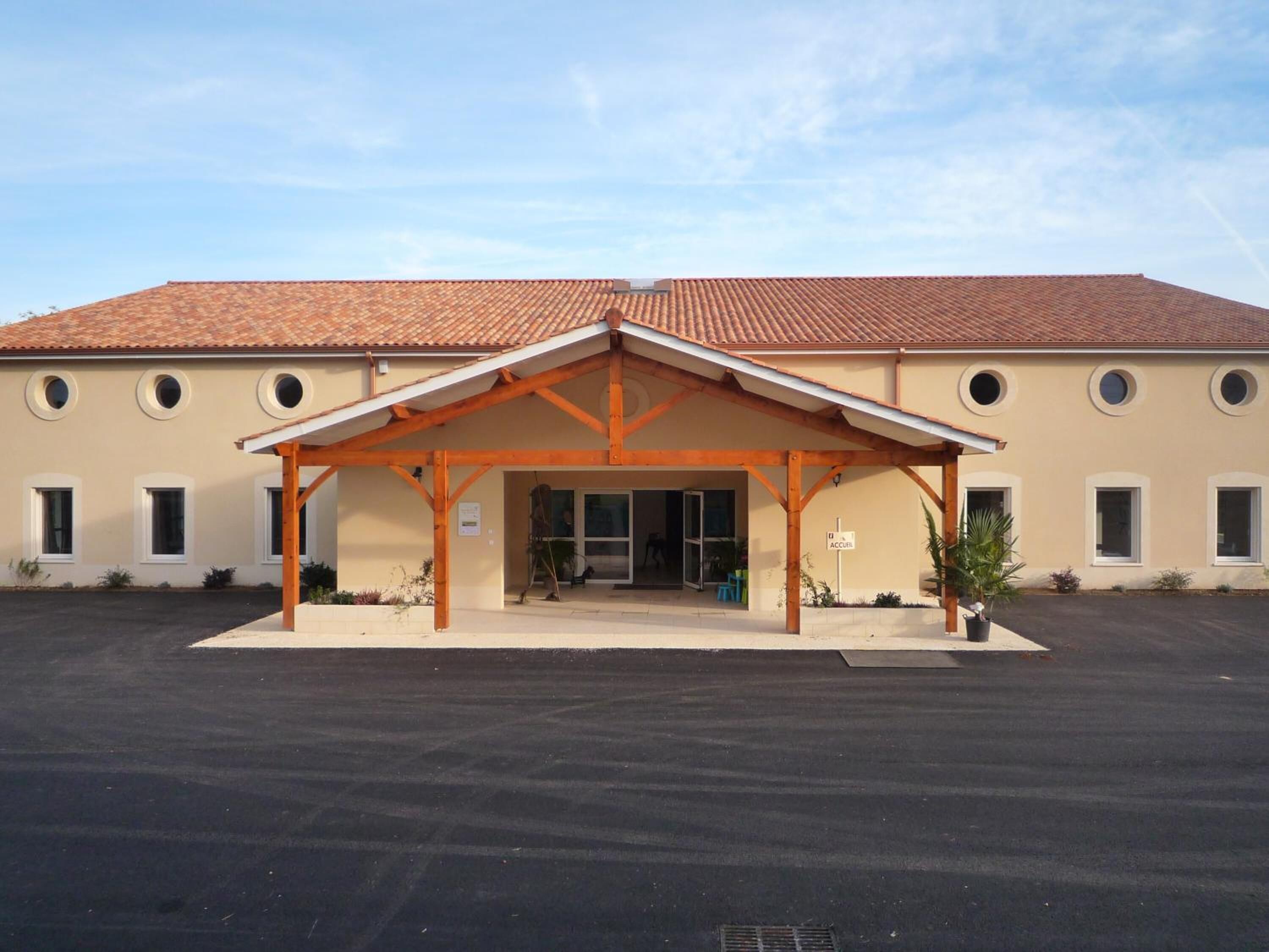 Un bâtiment doté d’une entrée couverte, d’un toit en tuiles et d’une enseigne indiquant « ACCELER ».