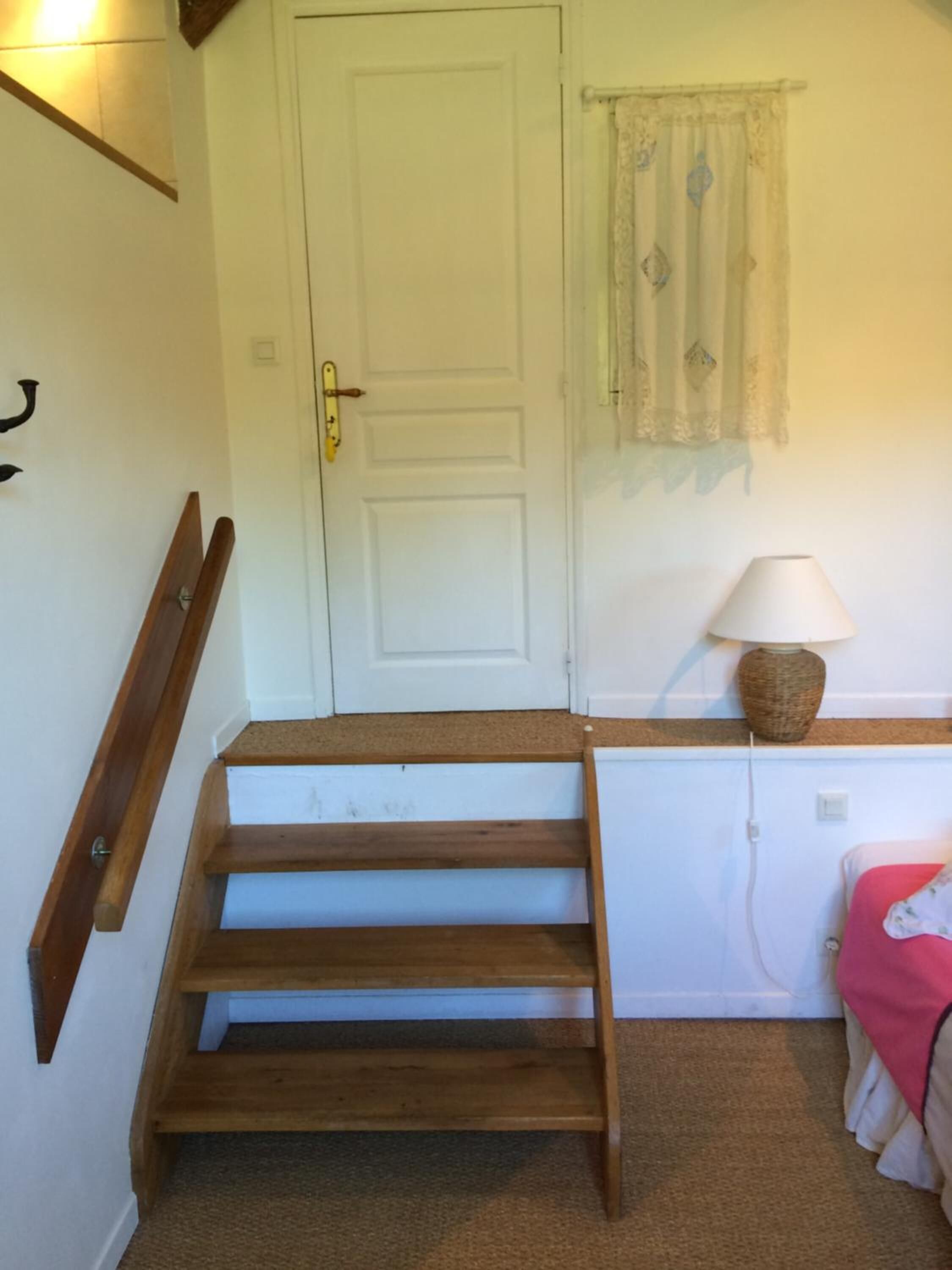 Una escalera con escalones de madera que conduce a una puerta blanca.