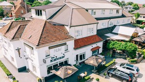 A hotel with a white facade, multiple windows, and a tiled roof. - De Kalvaar Hotel (Ninove)