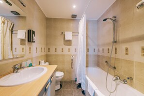 A modern bathroom with a sink, toilet, and bathtub. - De Kalvaar Hotel (Ninove)