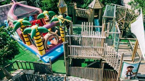 A playground with a slide, climbing structures, and a small building. - De Kalvaar Hotel (Ninove)
