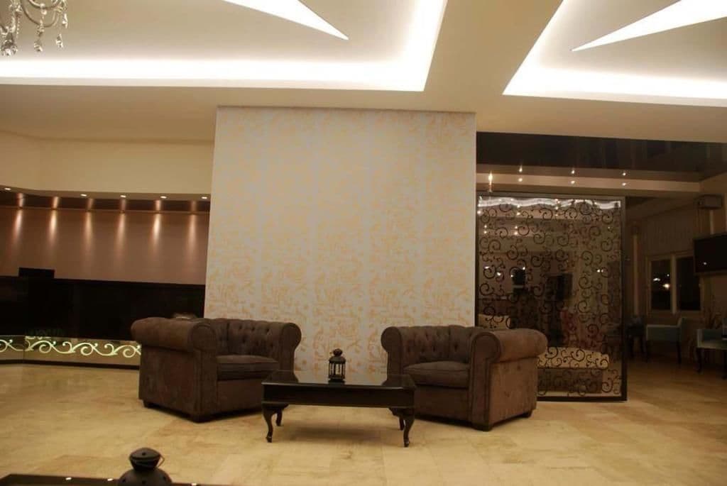 A modern lobby with two sofas facing each other, a coffee table, and a decorative wall with a patterned design.