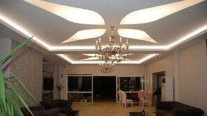 A spacious living room with a chandelier, sofas, and a coffee table. - Dikili Sunset Club (Dikili)