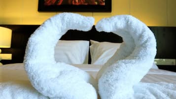 Una cama con dos grandes cisnes blancos hechos de toallas.