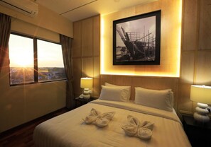 Habitación de hotel con una cama grande, un cuadro en la pared y vistas por la ventana.