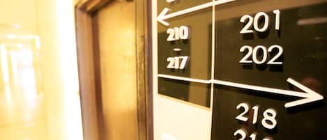 A hotel room number sign with arrows indicating directions to rooms 201, 202, 218, and 219.