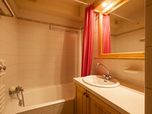 A bathroom with a bathtub, a sink, and a mirror. - 3* Studio for 4, near slopes and shops, garage, pets allowed (La Clusaz)