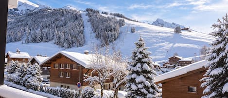 A snowy mountain village with wooden buildings and a clear sky.