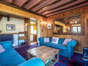 A cozy room with a blue sofa, a wooden coffee table, and a checkered floor. - Chalet near slopes, fireplace, pets allowed, garage, WIFI (La Clusaz)