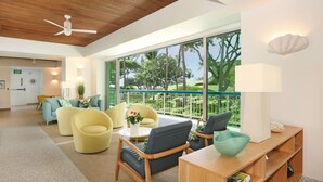 Un hall d’hôtel moderne avec un plafond en bois, de grandes fenêtres donnant sur un paysage verdoyant et un mobilier contemporain.