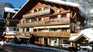 A multi-story wooden building with balconies, a restaurant, and a shop.