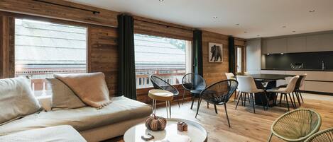 Ein modernes Wohnzimmer mit Sofa, Couchtisch und Essbereich.