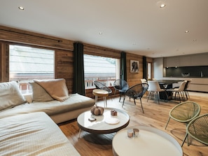 Ein modernes Wohnzimmer mit Sofa, Couchtisch und Essbereich.
