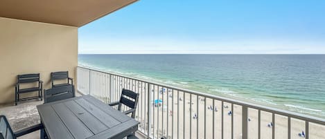 A balcony with a view of the beach and ocean.