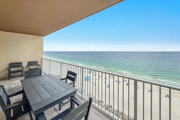A balcony with a view of the beach and ocean.
