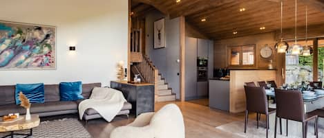 A spacious living area with a sofa, a bean bag chair, and a dining table with chairs.