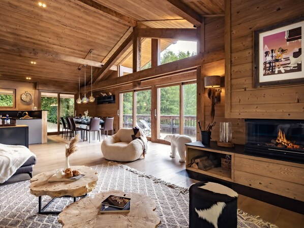 A spacious living area with a fireplace, large windows, and a cozy seating arrangement.