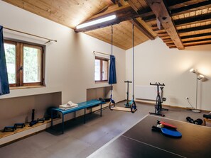 A gym with exercise equipment, a bench, and a window.