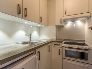 A modern kitchen with white cabinets, stainless steel appliances, and a wooden countertop. - 2** Apartment for 4, near slopes, pets allowed (La Clusaz)