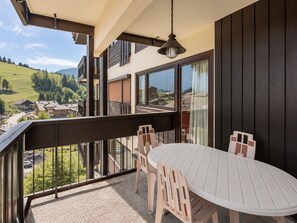 A balcony with a table and chairs, overlooking a scenic landscape. - 2** Apartment for 4, near slopes, pets allowed (La Clusaz)