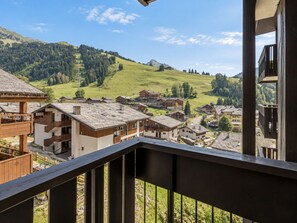 A mountain village with traditional wooden buildings and a view of the surrounding hills. - 2** Apartment for 4, near slopes, pets allowed (La Clusaz)