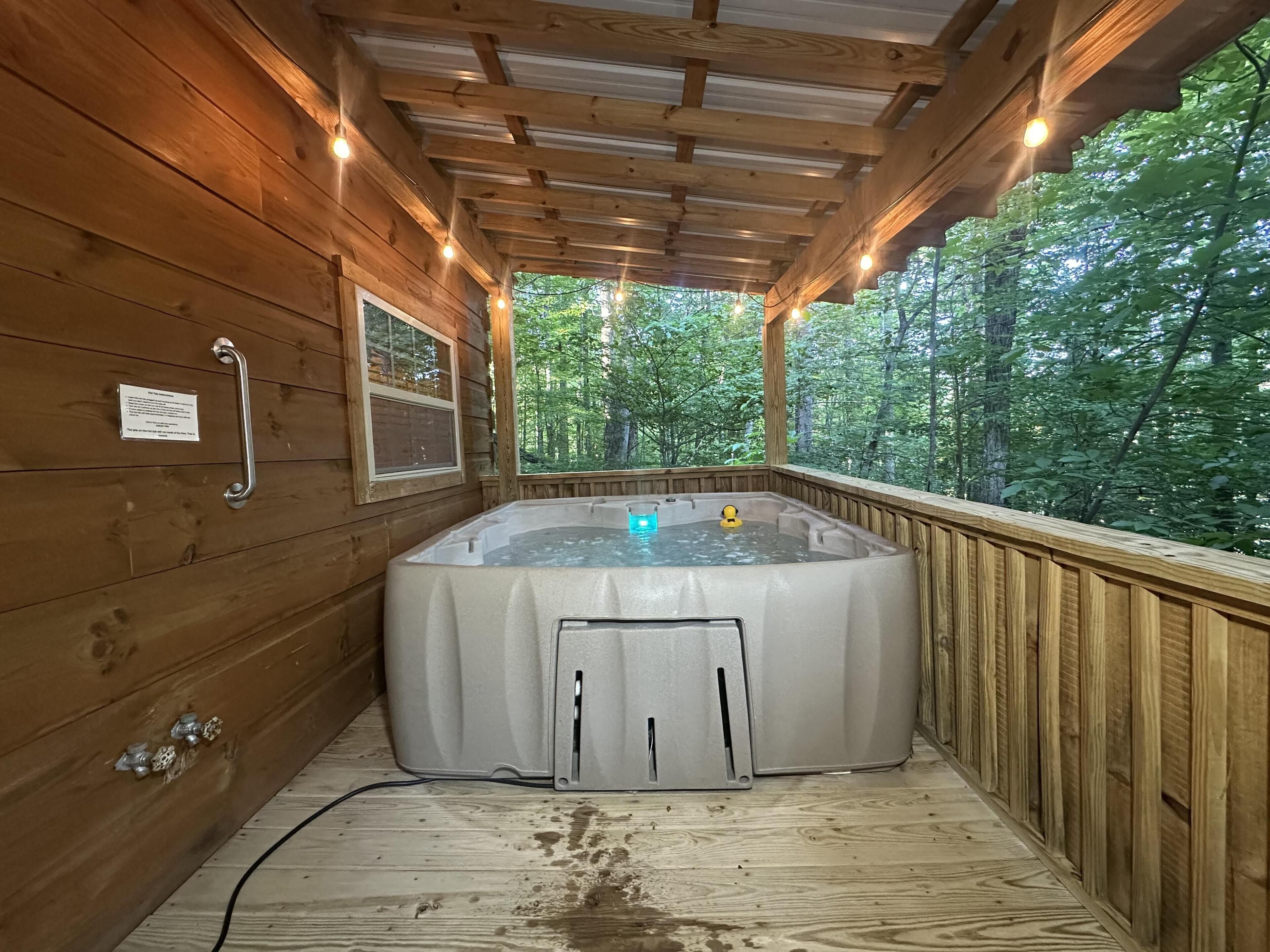 Ett bubbelbad i en stuga av trä, med en träveranda och utsikt över skogen.