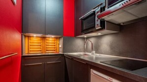 A compact kitchen with a microwave, oven, and Bosch dishwasher. - 3* Apartment in La Clusaz, 5 guests, parking (La Clusaz)