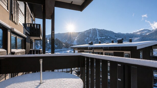 A balcony with a snow-covered table, a view of snow-covered mountains, and a clear sky. - 3* Apartment in La Clusaz, 5 guests, parking (La Clusaz)