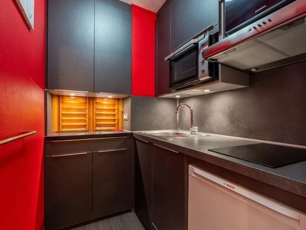 A compact kitchen with a microwave, oven, and Bosch dishwasher.