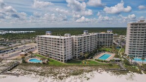A multi-story hotel with a pool area, surrounded by a beach and a parking lot. - DIRECT GULF FRONT UNIT, CHARMING FIRST FLOOR LOCATION, TONS OF FAMILY AMENITIES, (Orange Beach)