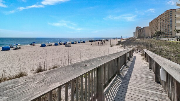 A beach with a wooden boardwalk leading to a hotel. - DIRECT GULF FRONT UNIT, CHARMING FIRST FLOOR LOCATION, TONS OF FAMILY AMENITIES, (Orange Beach)