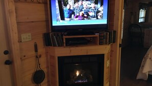 Un televisor sobre una repisa de madera, encima de la chimenea.