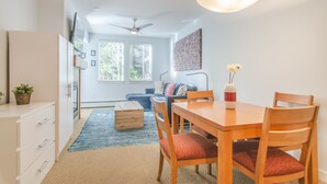 Une cuisine moderne avec un coin repas, des meubles en bois et un ventilateur de plafond.