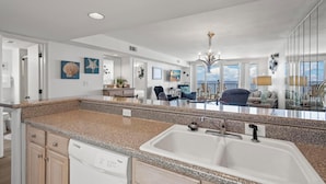 A modern kitchen with granite countertops, a double sink, and wooden cabinets. - DIRECT GULF FRONT UNIT, INCREDIBLE UNCROWDED BEACHES, CONVENIENT LOCATION (Orange Beach)