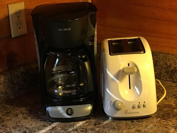 Eine Kaffeemaschine und ein Toaster auf einer Küchenarbeitsplatte.