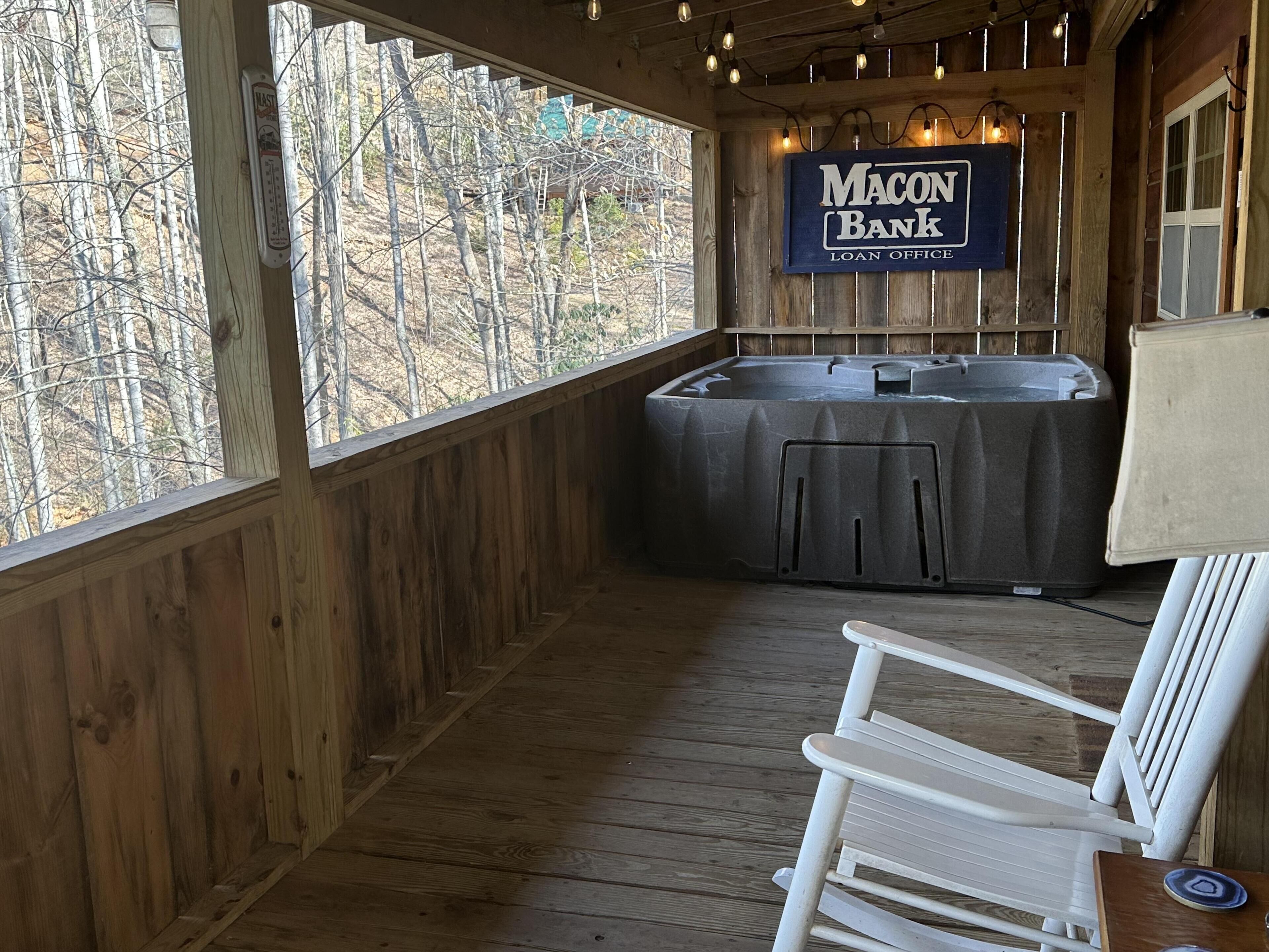 Eine Holzterrasse mit einem Whirlpool, einem Stuhl und einem Schild für die Macon Bank Darlehensstelle.
