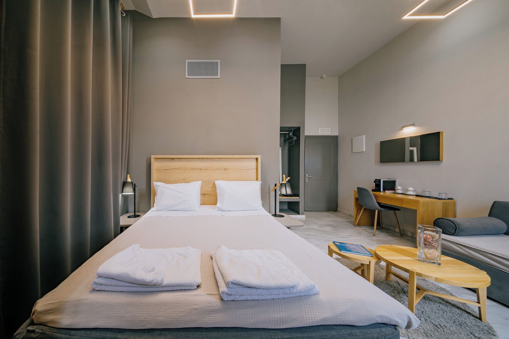 Una habitación de hotel con una cama grande, un escritorio, una silla y una mesita con toallas.