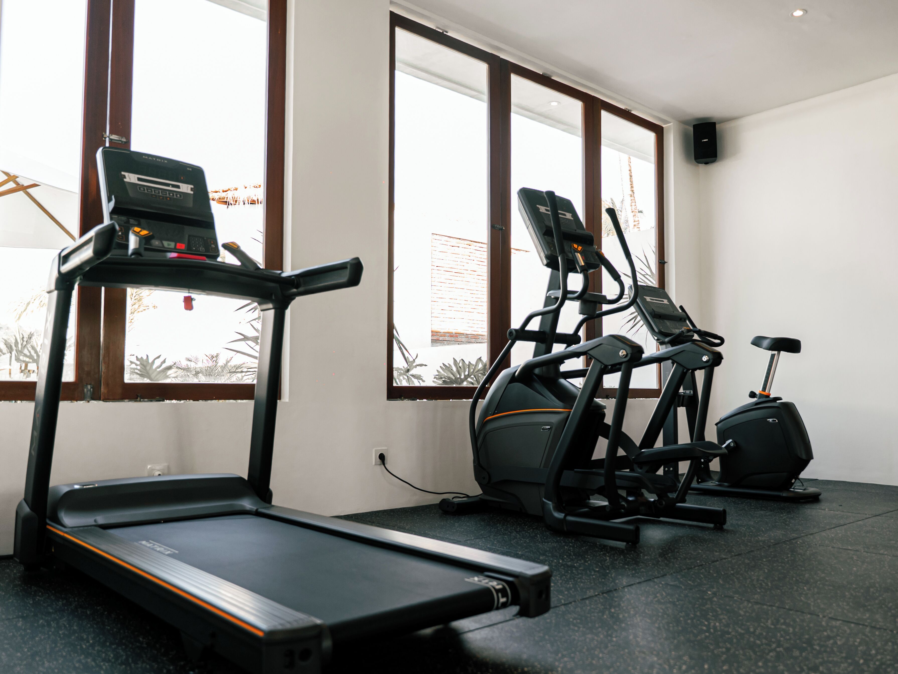 A gym with treadmills, an elliptical, and a stationary bike.
