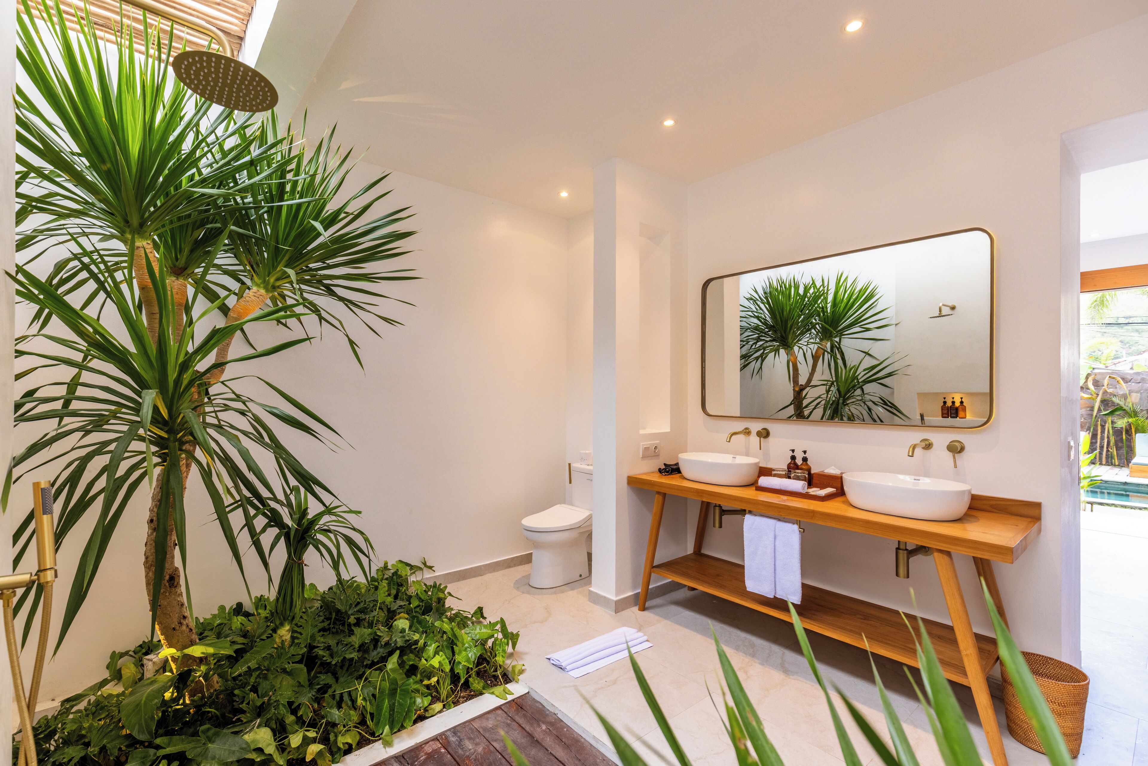 A modern bathroom with two sinks, a large mirror, and a shower.